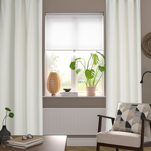 Acogedora sala de estar con ventana, planta, silla y libros.