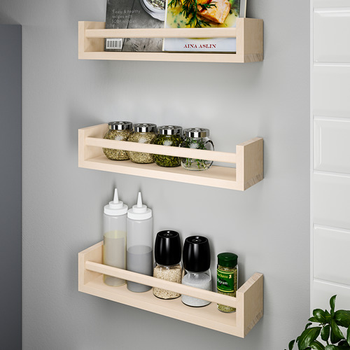 Tres estantes de madera montados en la pared que contienen artículos de cocina: frascos, botellas y libros de cocina. Ideal para organizar y exponer especias y recetas.