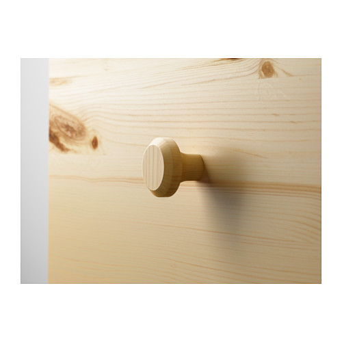Primer plano de pomos redondos de madera sobre una superficie de madera de color claro, resaltando la veta natural y el acabado liso.