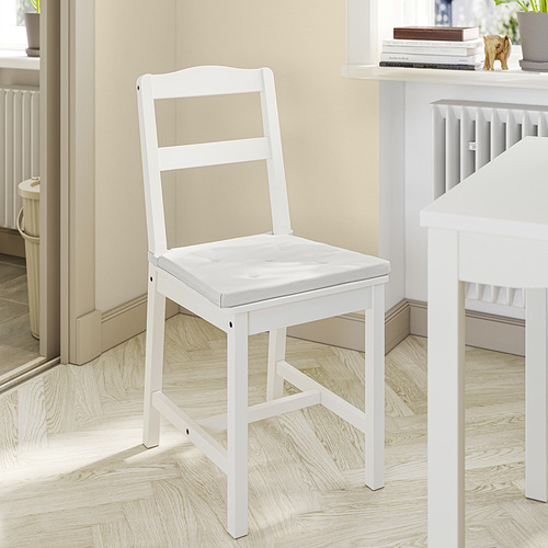 Una silla de comedor HAUGA de pino macizo blanco con diseño de respaldo de escalera, ideal para espacios reducidos.