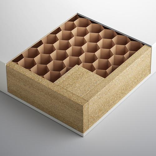 Caja de almacenaje hexagonal de color beige con papel de nido de abeja en su interior, apoyada sobre una superficie gris.