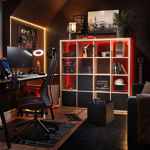 Oficina en casa con estante KALLAX, luces rojas, guitarra, escritorio, silla, monitor, teclado y planta.