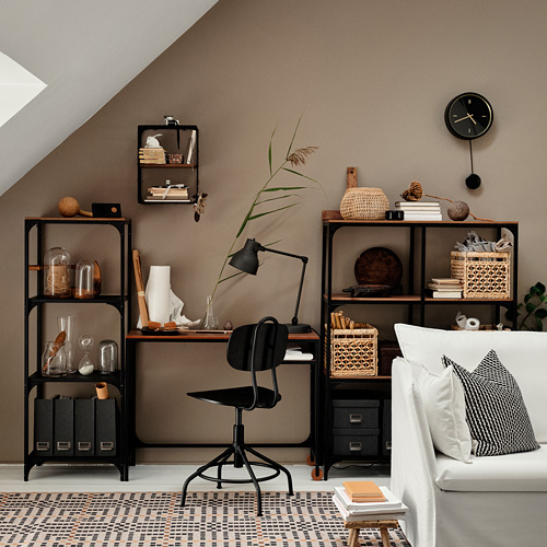 Acogedora oficina en casa con tonos neutros; silla, estantes y lámpara negros sobre escritorio de madera; Sofá blanco con almohada negra.