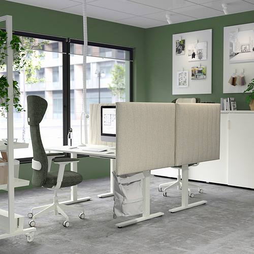 Oficina moderna con pantallas acústicas MITTZON beige, tela gris, separadores en escritorios, paredes verdes, gran ventanal, plantas y decoración contemporánea.