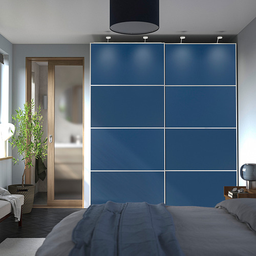 Dormitorio con grandes armarios correderos azules. Los armarios cubren la pared, más grande que la cama, con puertas grises de cierre suave.