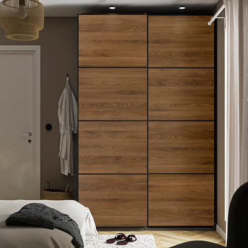 Dormitorio moderno MEHAMN gran armario corredero con acabado en madera. Se extiende por la pared, más alto que la puerta y la cama, con puertas de cierre suave.