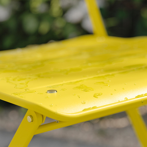 Silla plegable SUNDSÖ amarilla, color brillante, construcción metálica, gotas de agua en el asiento.