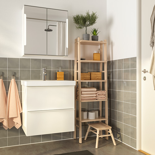 Baño moderno con estantes de abedul, toallas, plantas y tocador. Toallas de rubor, alfombra gris, ambiente sereno con paredes de azulejos grises.