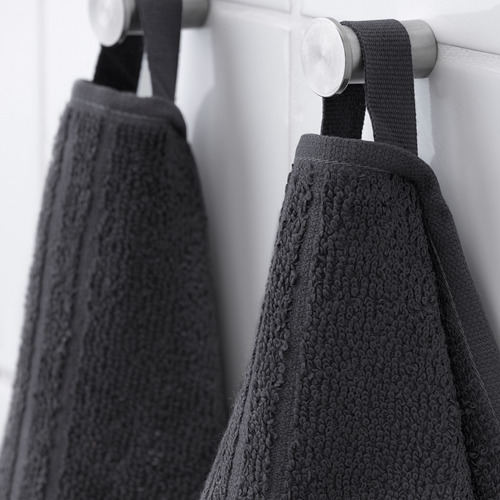 Dos toallas de color gris oscuro cuelgan de un estante de metal, mostrando su material suave y absorbente y su diseño práctico.