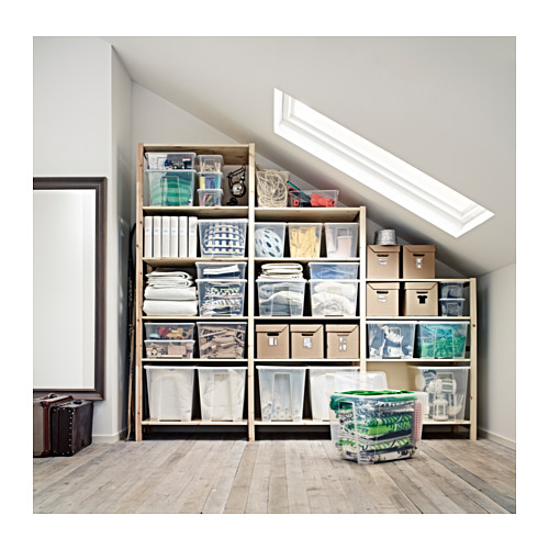 Ático con estantes IVAR llenos de contenedores de almacenamiento organizados; Recipientes transparentes, beige y verdes en estantes de madera.
