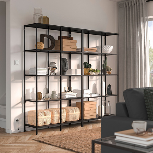 Sala de estar moderna con estantería VITTSJÖ, silla gris y ventanas.