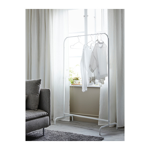Un perchero blanco minimalista de MULIG con perchas se encuentra cerca de una ventana, mostrando ropa blanca.