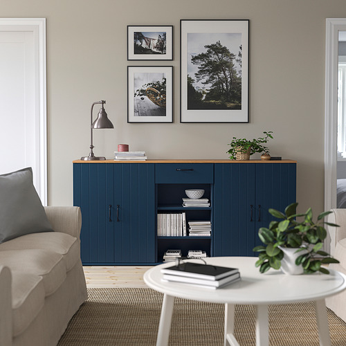 Moderno living comedor con muebles SKRUVBY azules, fotos, y sillón beige.