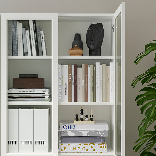 White bookcase with multiple shelves, storing books, decorative items, and games. Adjustable shelves and panel doors for versatile storage.