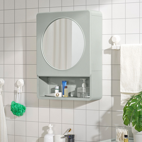 Mueble de baño IVÖSJÖN verde con espejo, almacenamiento abierto y cerrado, azulejos blancos, toallas, esponja.