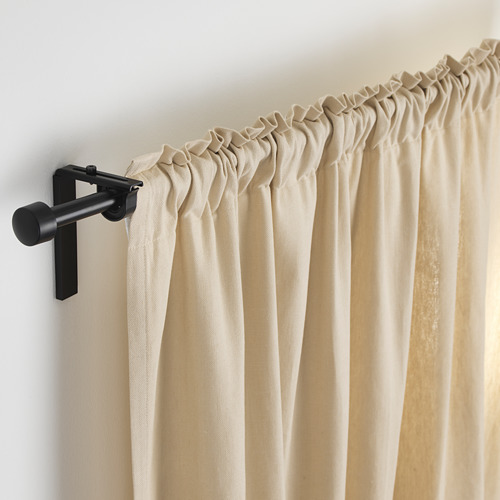 Barra de cortina negra con longitud ajustable y soporte en ángulo que soporta cortinas beige.