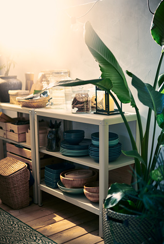Estantería blanca KOLBJÖRN con decoración, platos, cuencos y plantas.