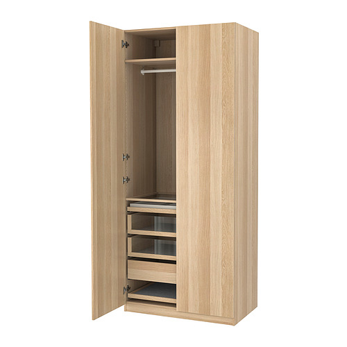 Un armario abierto PAX de madera marrón claro con estantes y cajones.