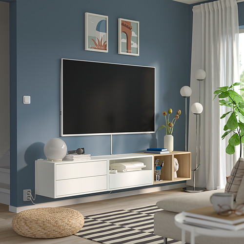 Moderno salón azul con mueble de televisión EKET, pósters, lámpara, planta y alfombra.
