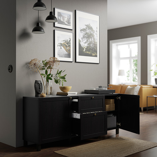 Sala de estar moderna con aparador negro abierto que muestra almacenamiento y elementos decorativos en la parte superior.