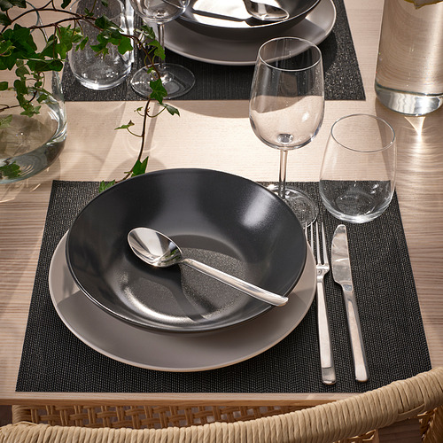 Mesa con manteles individuales, platos, cubiertos y copas de vino FLYGFISK negros y grises.