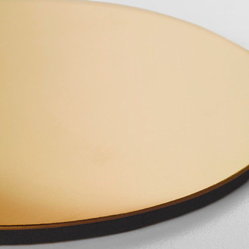 Mantel redondo de color dorado sobre superficie blanca. Suave, con bordes metálicos, que amortigua el sonido.