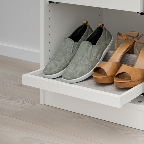 Estantería extraíble blanca con zapatillas grises y sandalias marrones, parte del sistema de almacenamiento KOMPLEMENT de ikeas para un acceso organizado al armario.