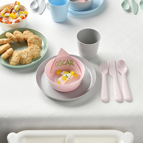 Juego de cubiertos de plástico para niños con cuchillo de sierra, tazones, tazas y biscotti de colores pastel en platos, etiqueta con el nombre de Oscar en servilleta.