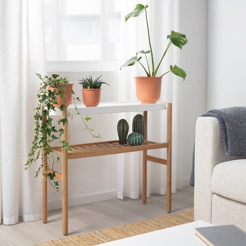Soporte de plantas SATSUMAS con 3 plantas en maceta. Madera natural, se adapta a la habitación con sofá blanco y cortinas.