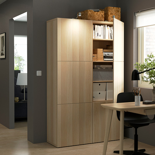 Light wood storage unit with open shelves holding books and baskets, closed cabinets below. Perfect for home office organization.