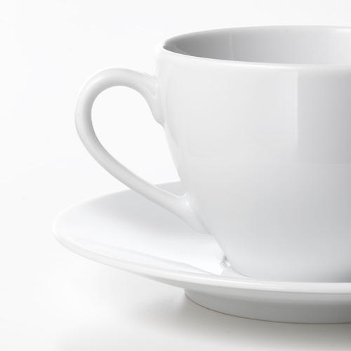 Taza de porcelana blanca de alta calidad, mango liso, se asienta sobre un platillo a juego.