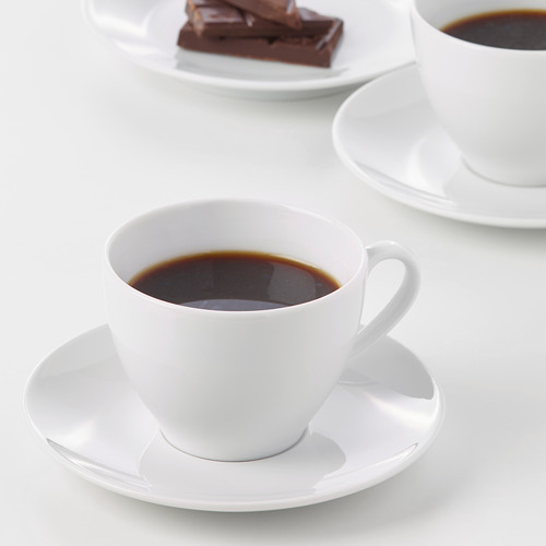 Dos tazas de café de porcelana blanca sobre platillos, duraderas y diseñadas tanto para uso diario como formal.