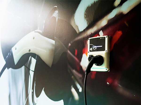Charging cable plugged into a wall station for electric vehicles.