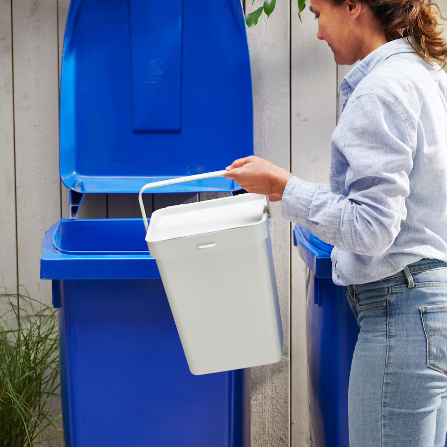 Woman holding a HÅLLBAR waste sorting bin