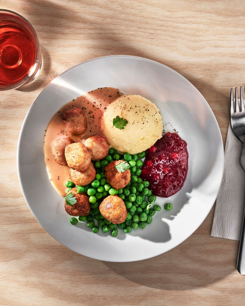 Cozy dining table with home-style meal featuring IKEA 365+ plate, DRAGON fork and HUVUDROLL vegetable balls.