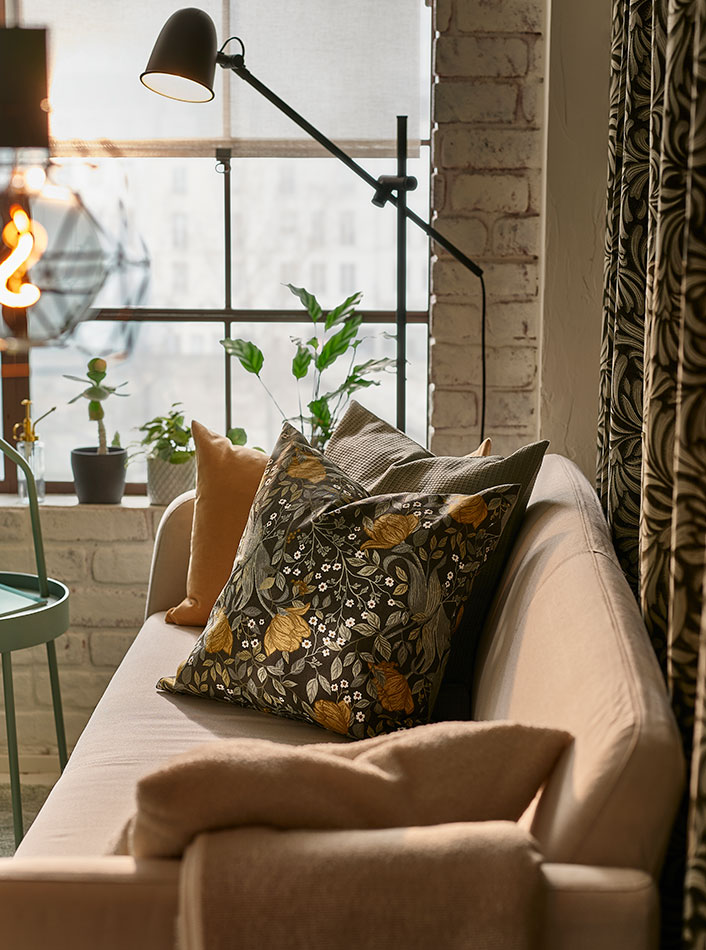 A LINANÄS 2-seat sofa with a BURVIK side table at the end and also PERSILLADE plant pots at the end.