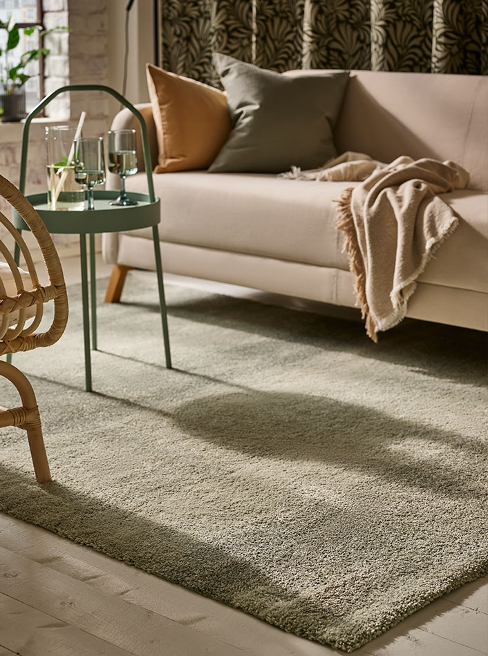A LINANÄS 3-seat sofa with a GUNNEMOR throw and a BURVIK side table with OMBONAD glass cups.