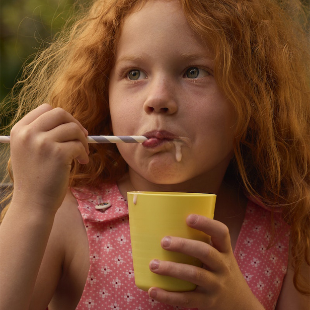 red-haired girl eating in a yellow cup