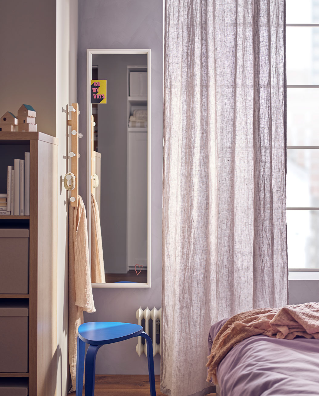 Full-length mirror, underneath there is a small blue box with a window next to it.