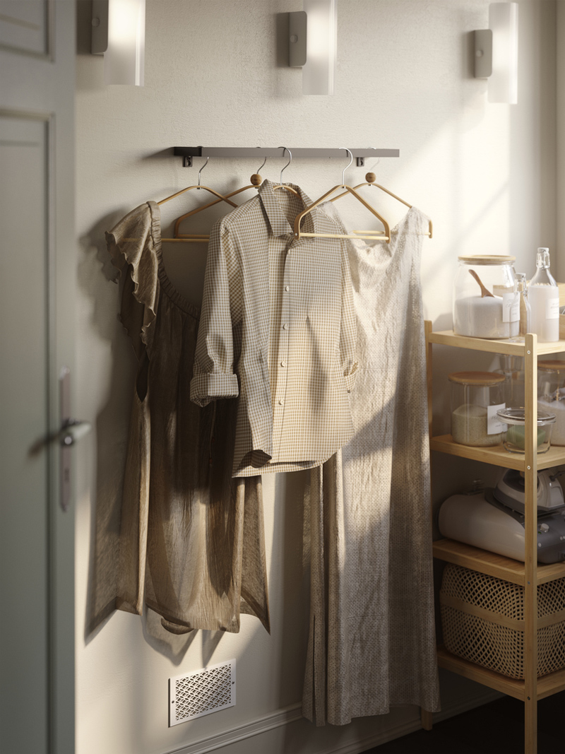 Neutral-toned clothings on HÖSVANS bamboo hangers beside a RÅGRUND bamboo shelving unit.