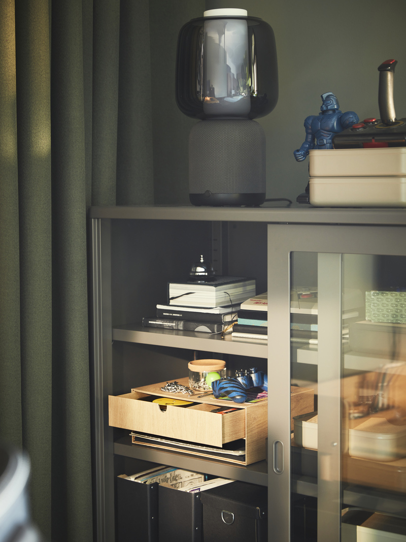 An IDÅSEN cabinet with sliding doors and a SYMFONISK smart Wi-Fi lamp.