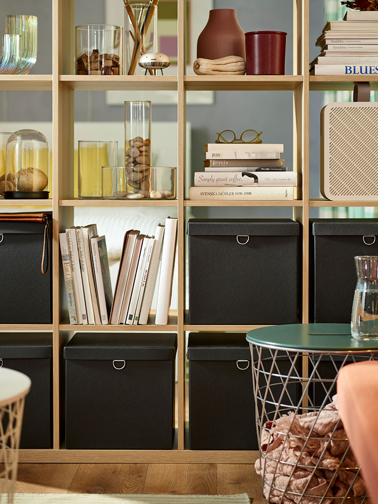 Open closet in pine wood, with several organizer boxes and books.