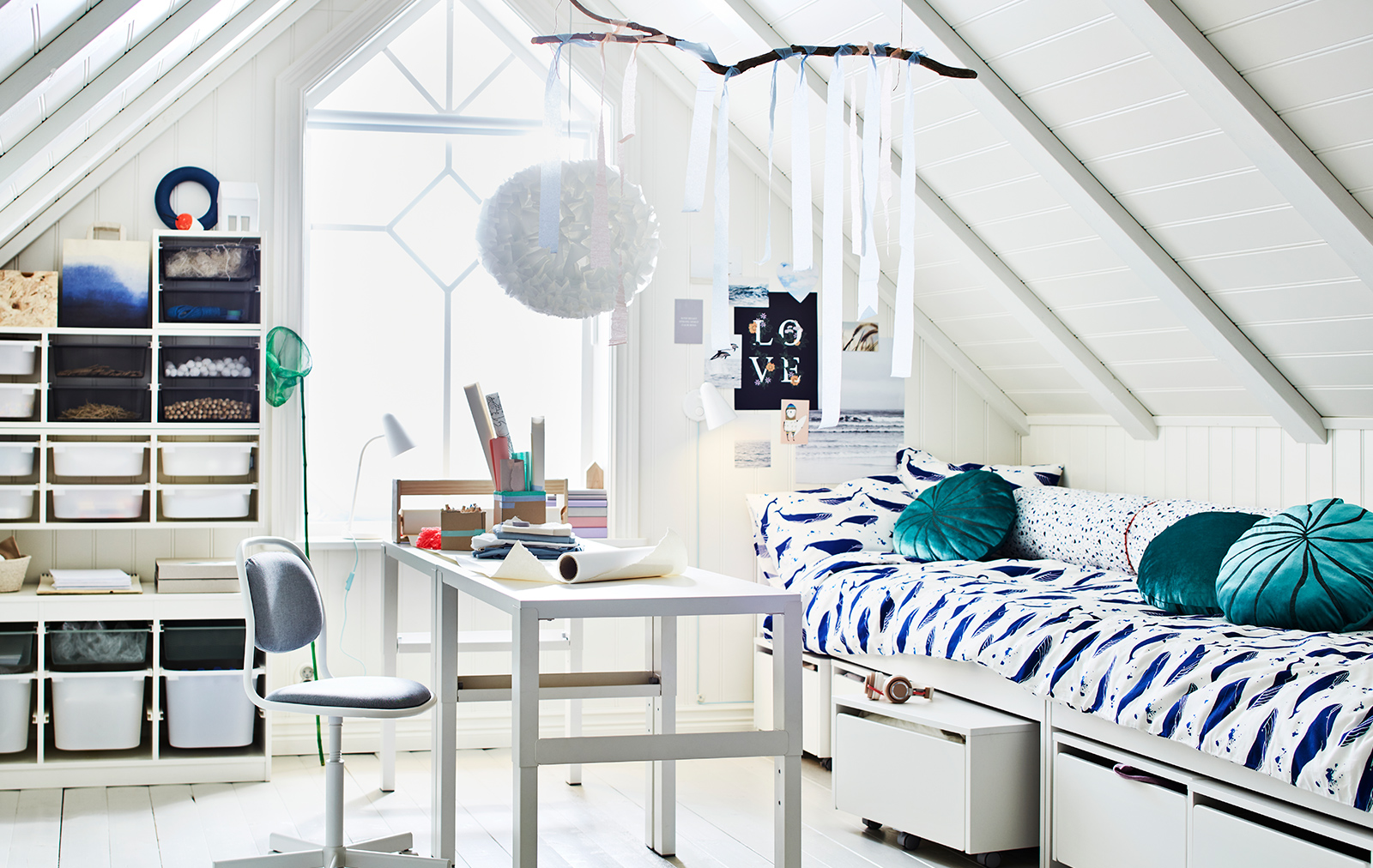 A bedroom with a PAHL desk and an ORFJÄLL desk chair in the middle, and a SLAKT bed with 3 storage boxes on the right.