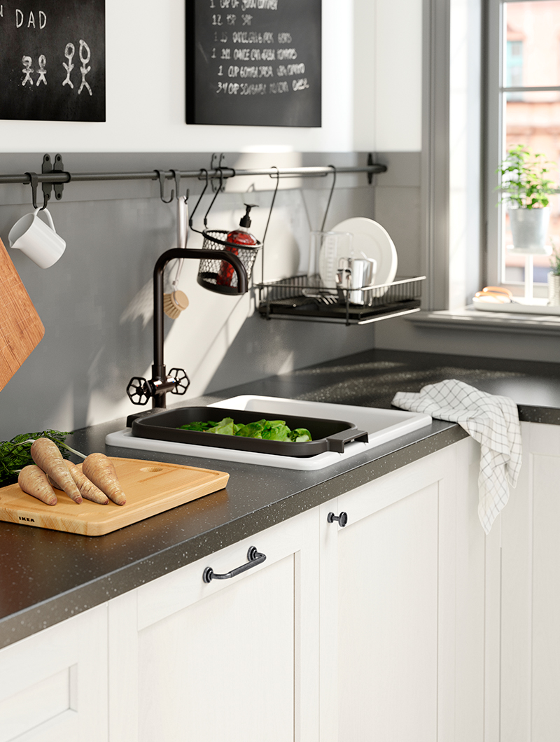 White HAVSEN kitchen sink with black tap, dish drainer, and wall accessories in a modern IKEA kitchen.