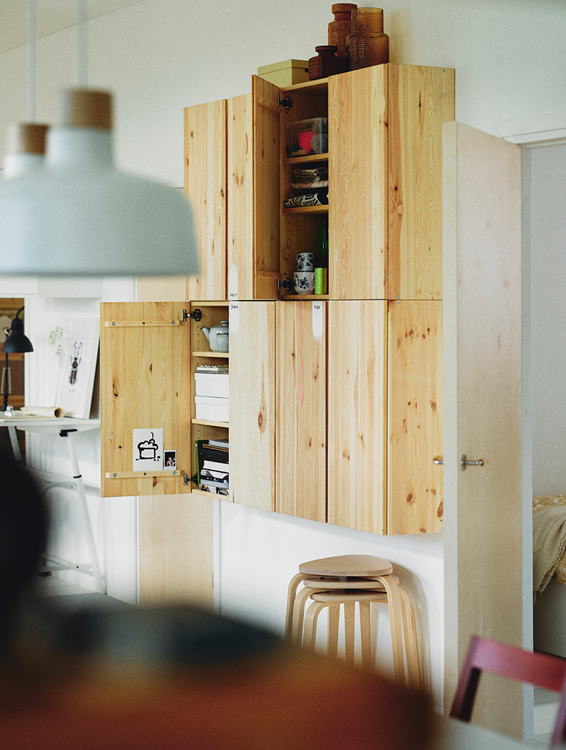 A wall cabinet with IVAR doors, with three stacked KYRRE stools underneath and BUNKEFLO ceiling lamps above.
