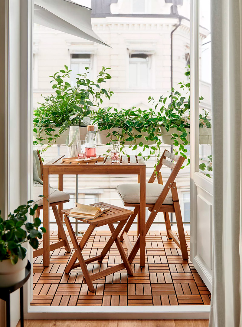 Wooden balcony furniture set with folding chairs and table, perfect for small outdoor urban spaces.