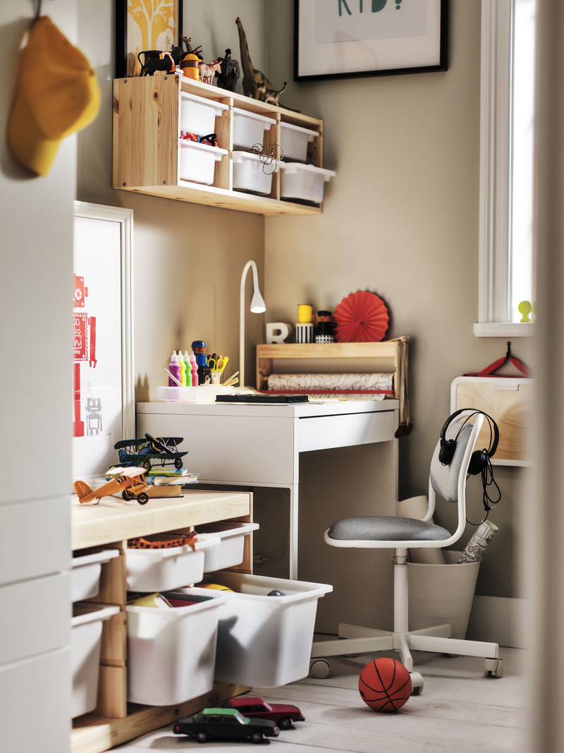 Children's room with a white desk, gray chair, and wooden shelves with storage. An organized and creative ambiance for study and play.