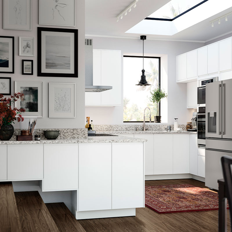 Bright white kitchen with modern cabinets, granite counters, art wall, and red rug.
