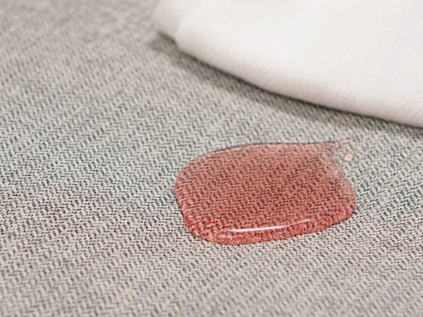 Light-colored textile with red spill and cloth for easy cleaning