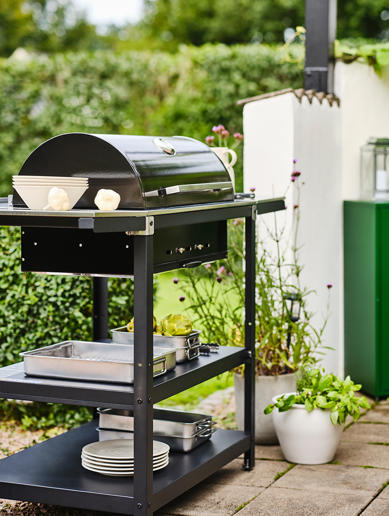 a black barbecue can be seen in a garden space.